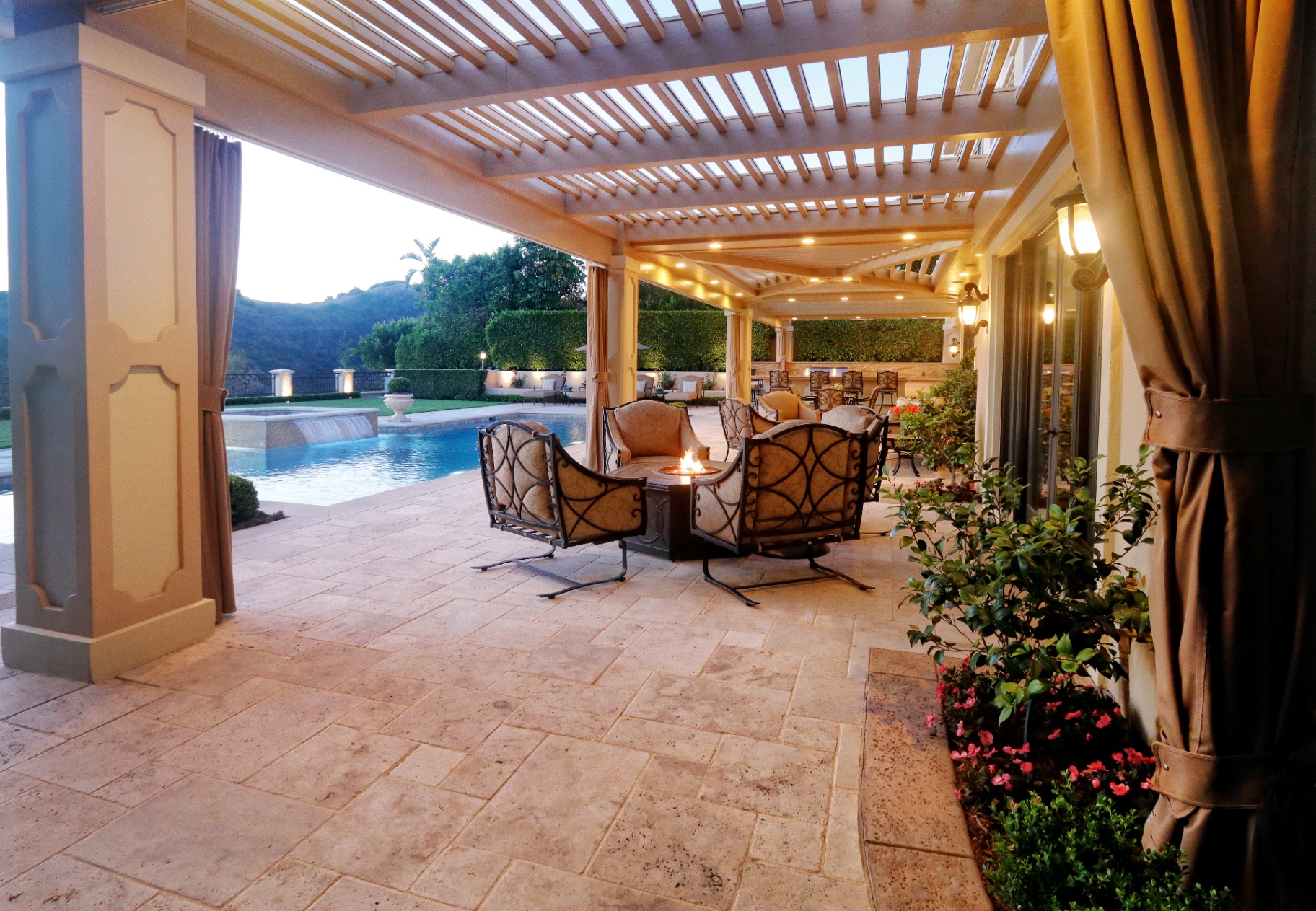 BSH Outdoor Living Spaces — covered pergola with wrought-iron seating and fire pit